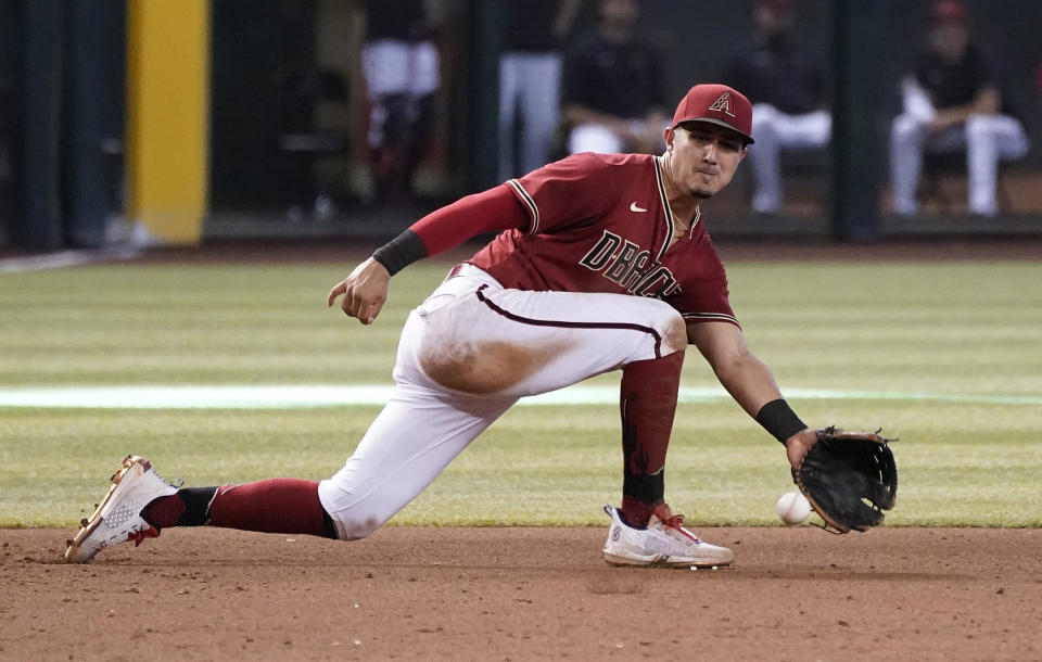 Arizona Diamondbacks third baseman Josh Rojas fields a grounder against the Colorado Rockies during the ninth inning of a baseball game, Sunday July 10, 2022, in Phoenix. (AP Photo/Darryl Webb)