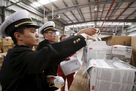 Officers show fake masks after being seized by customs in Shanghai, China, December 8, 2015. REUTERS/Stringer