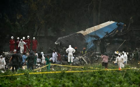 Rescue teams search through the wreckage site of a Boeing 737 that plummeted into a cassava field on Friday - Credit:  Ramon Espinosa/AP