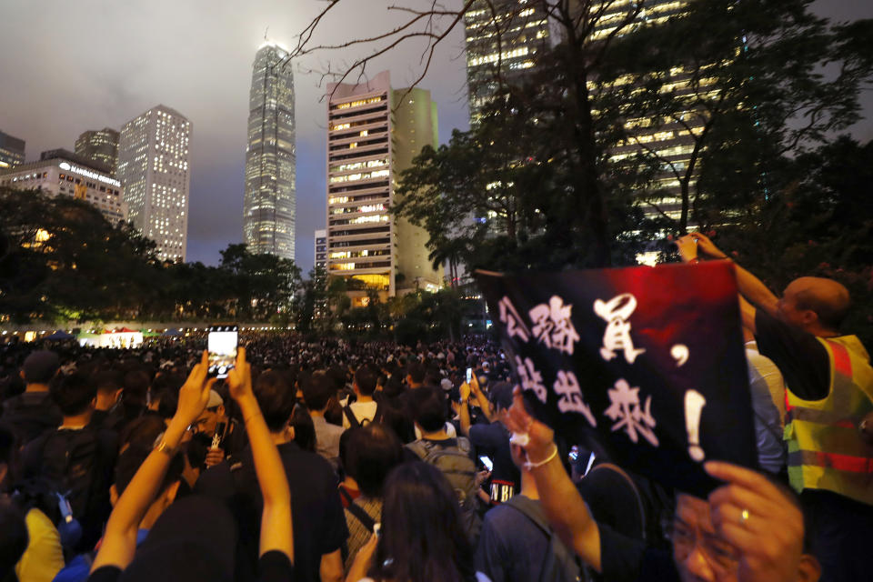 A man holds up a sign that reads: "Civil servants, stand out!" during a demonstration in Hong Kong Friday, Aug. 2, 2019. Protesters plan to return to the streets again this weekend, angered by the government's refusal to answer their demands, violent tactics used by police - possibly in coordination with organized crime figures. (AP Photo/Vincent Thian)