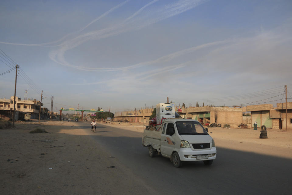 Syrians flee shelling by Turkish forces in Ras al Ayn, northeast Syria, Wednesday, Oct. 9, 2019. Turkish President Recep Tayyip Erdogan announced Wednesday the start of a Turkish military operation against Kurdish fighters in northeastern Syria. (AP Photo/Baderkhan Ahmad)