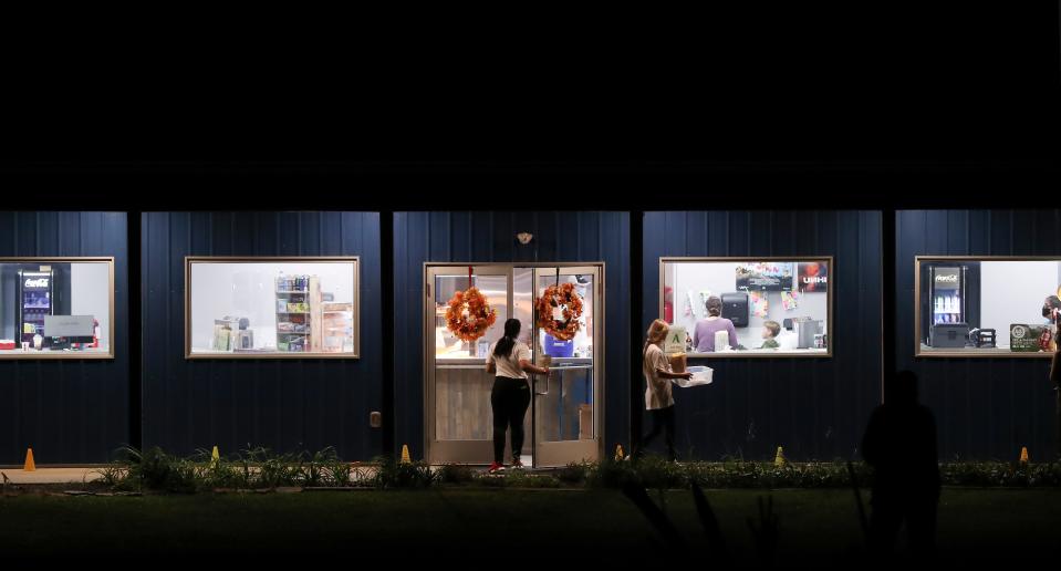 Employees deliver concession items to guests before a premier showing of the Disney production Clouds at the Sauerbeck Family Drive In in LaGrange, Ky. on Oct. 12, 2020.  The drive in has been doing well despite the Covid-19 era.