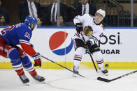 Chicago Blackhawks center Max Domi (13) passes against New York Rangers right wing Julien Gauthier (12) during the second period of an NHL hockey game, Saturday, Dec. 3, 2022, in New York. (AP Photo/Jessie Alcheh)