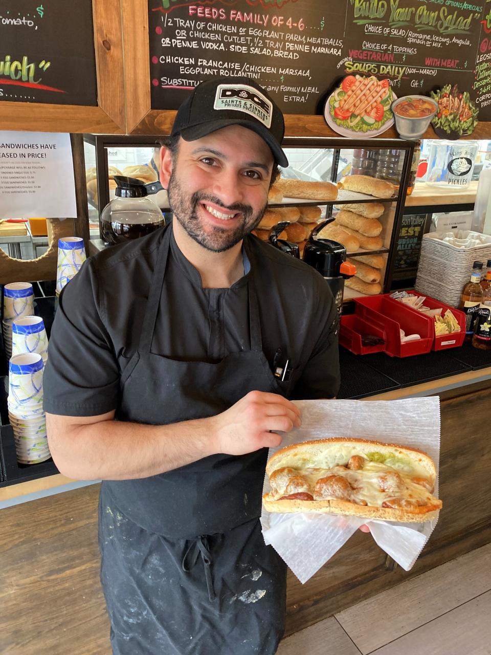 Frank Ficarra, the owner of Leonardo's Italian Deli in New City with  "The Johnny Utah," a hero with meatballs, marinara, provolone and pesto. Photographed Jan. 30, 2023