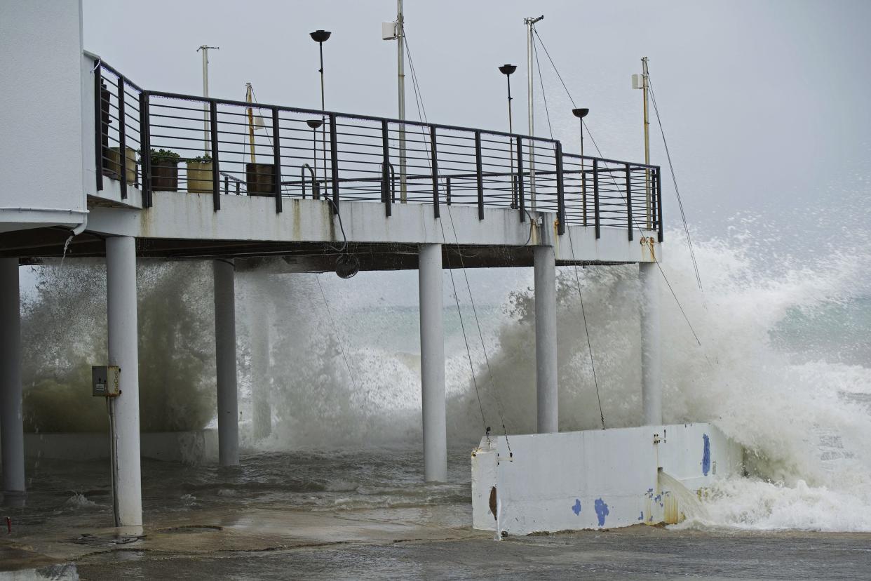 Waves crash against the patio of Lobster Pot restaurant as Hurricane Ian passes through George Town, Grand Cayman island, Monday, Sept. 26, 2022.