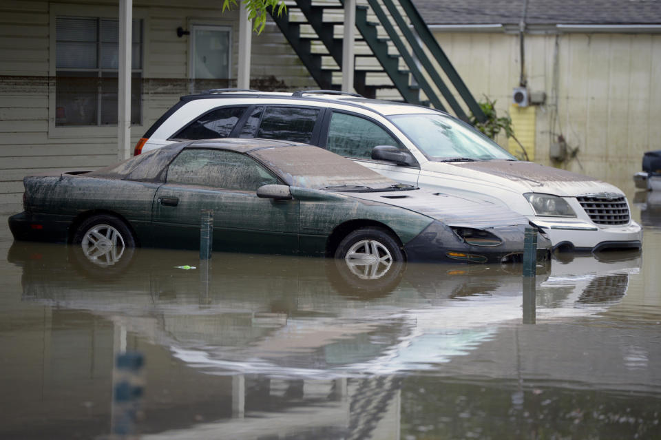 Two cars are covered in sediment as floodwaters recede along Strong Street in Pensacola, Fla., Wednesday, April 30, 2014. ensacola, Florida, got more rain on Wednesday than drought-struck Los Angeles has had in more than two years. (AP Photo/G.M. Andrews)