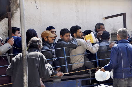 Residents wait in line to receive food aid in Yarmouk camp April 14, 2015. REUTERS/Moayad Zaghmout