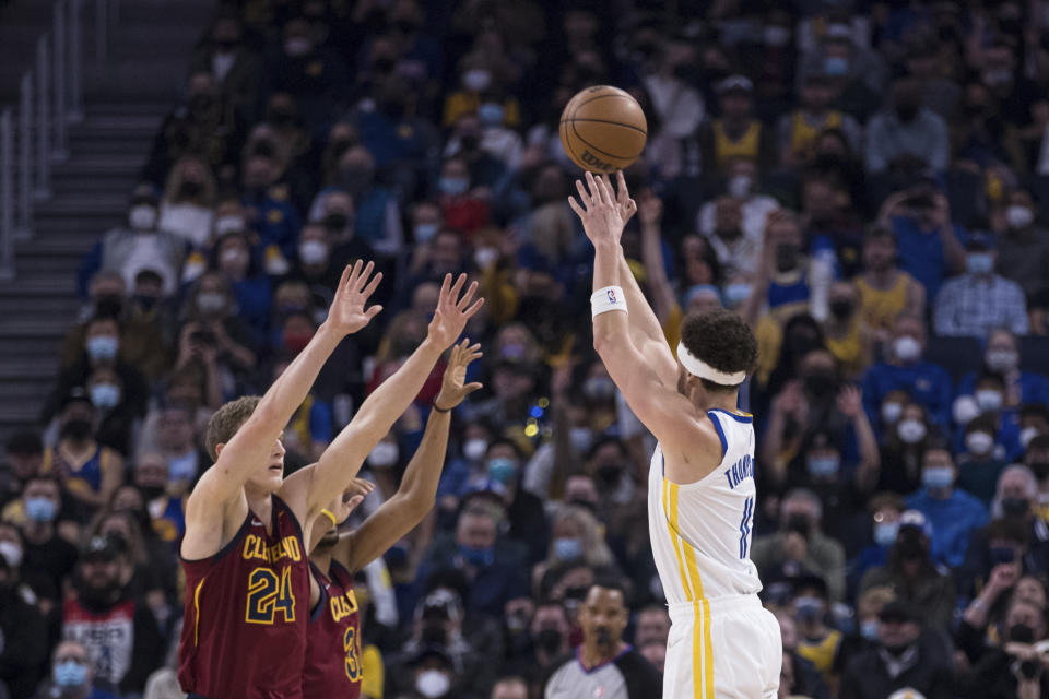 Golden State Warriors guard Klay Thompson, right, attempts a 3-point shot over Cleveland Cavaliers forward Lauri Markkanen (24) during the first half of an NBA basketball game in San Francisco, Sunday, Jan. 9, 2022. (AP Photo/John Hefti)