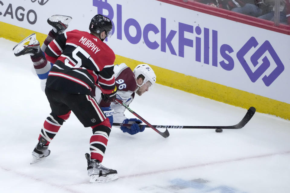 Chicago Blackhawks' Connor Murphy (5) checks Colorado Avalanche's Mikko Rantanen (96) during the first period of an NHL hockey game Thursday, Jan. 12, 2023, in Chicago. (AP Photo/Charles Rex Arbogast)