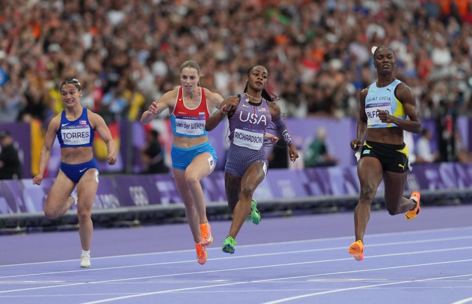 Former Texas sprinter Julien Alfred, right, holds off Sha'Carri Richardson of the United States to win gold in the 100-meter dash for Saint Lucia.