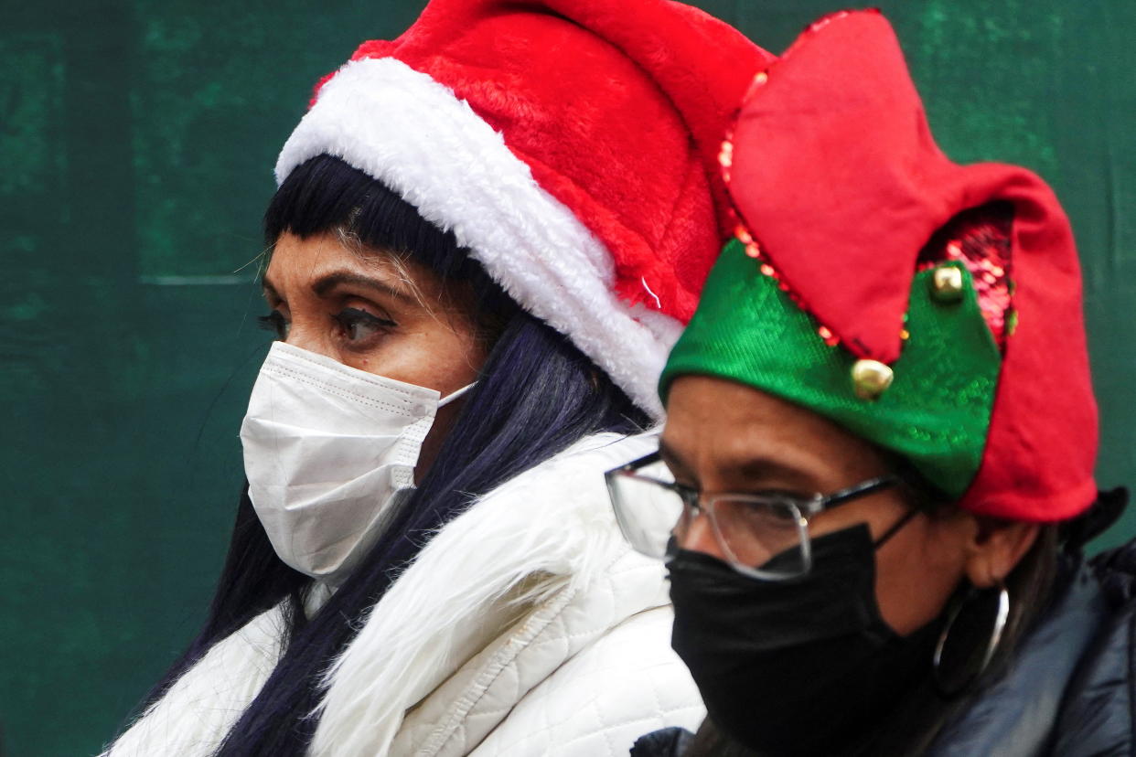 People wearing festive hats wear masks as they walk through Times Square during the coronavirus disease (COVID-19) pandemic in the Manhattan borough of New York City, New York, U.S., December 15, 2021.  REUTERS/Carlo Allegri