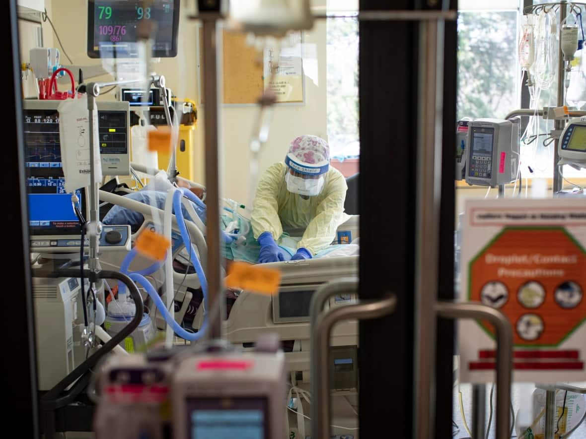 A nurse cares for a patient in the intensive care unit at Scarborough Health Network’s Centenary Hospital in Toronto. Hospitals across Ontario are experiencing staff shortages, with health-care workers reporting severe burnout and low morale. (Evan Mitsui/CBC - image credit)