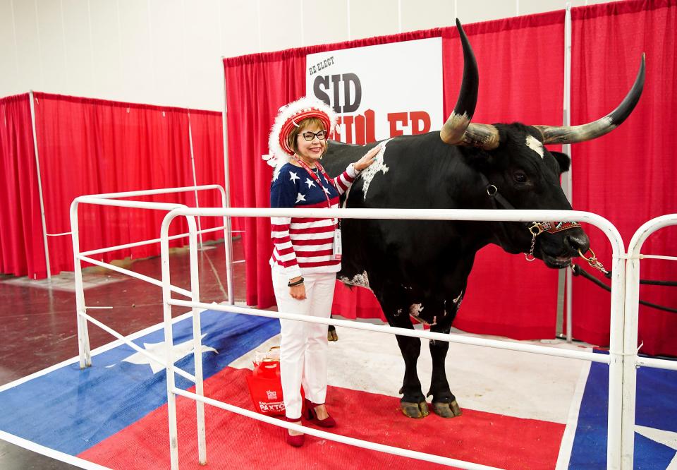 Elaine Wilmore of Cleburne, Texas, poses for a photo with Tex, a longhorn, at the Republican Party of Texas convention on June 16, 2022, in Houston.