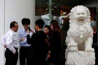 People play "Pokemon Go" during lunch time outside an office building after the augmented reality mobile game launched in the city in Hong Kong, China, July 26, 2016. REUTERS/Bobby Yip