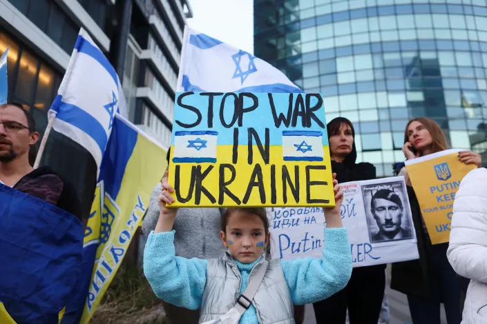 A girl holds a sign saying: Stop War in Ukraine. 