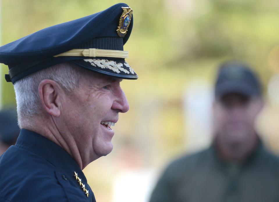 Retiring Yarmouth Police Chief Frank Frederickson gets a round of applause from a big crowd on hand outside the station Friday morning after he got a motorcycle escort into work.