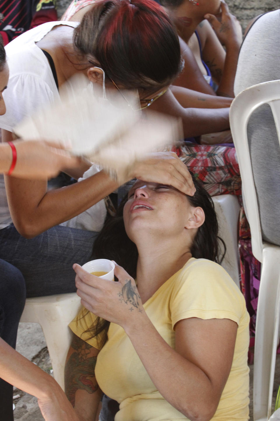 Luciana Santana is comforted by her mother as another person fans her, after identifying the remains of her brother at the coroner's office in Altamira, Brazil, Tuesday, July 30, 2019. Relatives of inmates killed during a prison riot in northern Brazil gathered in the coroner's office Tuesday to identify the 57 victims, with some passing out at seeing the beheaded corpse of a loved one. (AP Photo/Raimundo Pacco)