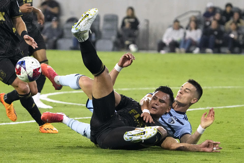 Los Angeles FC defender Denil Maldonado, left, and Sporting Kansas City midfielder Erik Thommy go down as they battle for the ball during the first half of a Major League Soccer match Wednesday, May 17, 2023, in Los Angeles. (AP Photo/Mark J. Terrill)