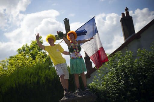 Fans wave a French flag as they wait for riders during the 41.5 km individual time-trial and ninth stage of the 2012 Tour de France cycling race starting in Arc-et-Senans and finishing in Besancon, eastern France