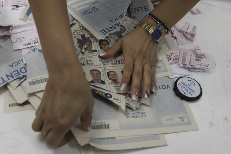 Unused ballots are torn up by an election worker at a polling station that closed on the day of presidential elections in Medellin, Colombia, Sunday, May 29, 2022. (AP Photo/Jaime Saldarriaga)