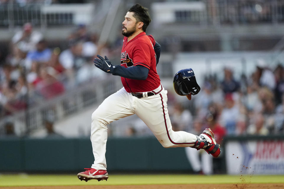 Atlanta Braves' Travis d'Arnaud loses his helmet as he runs to second base on a double against the Pittsburgh Pirates during the third inning of a baseball game Friday, June 10, 2022, in Atlanta. (AP Photo/John Bazemore)