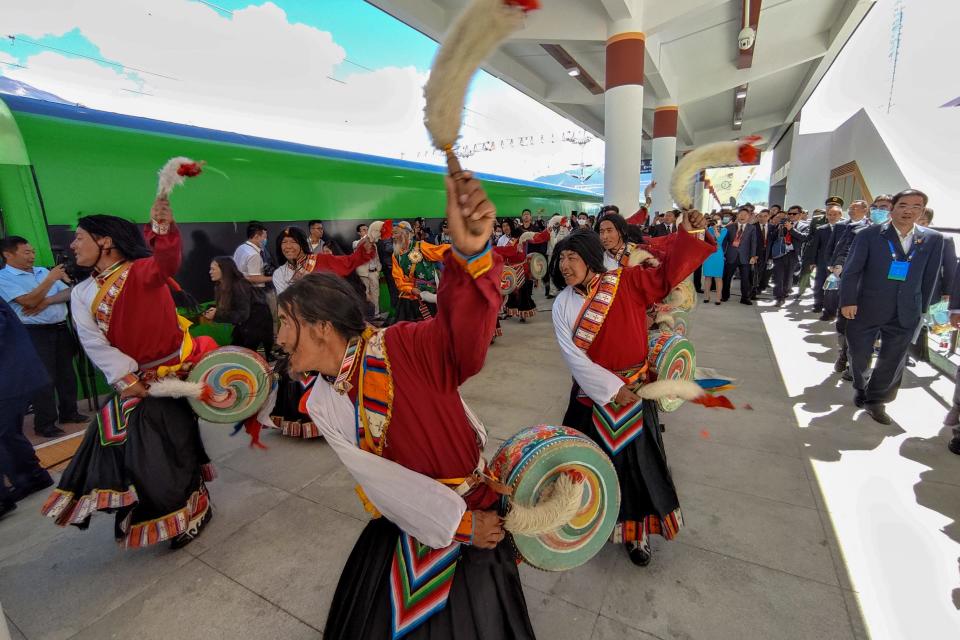 Local residents dance next to the first Fuxing bullet train at the station