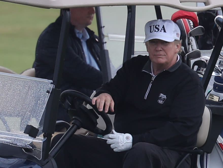 US President Donald Trump drives a golf buggy on his golf course at the Trump Turnberry resort in South Ayrshire, as part of their visit to the UK before leaving for Finland where he will meet Russian leader Vladimir Putin on Monday. (Getty Images)