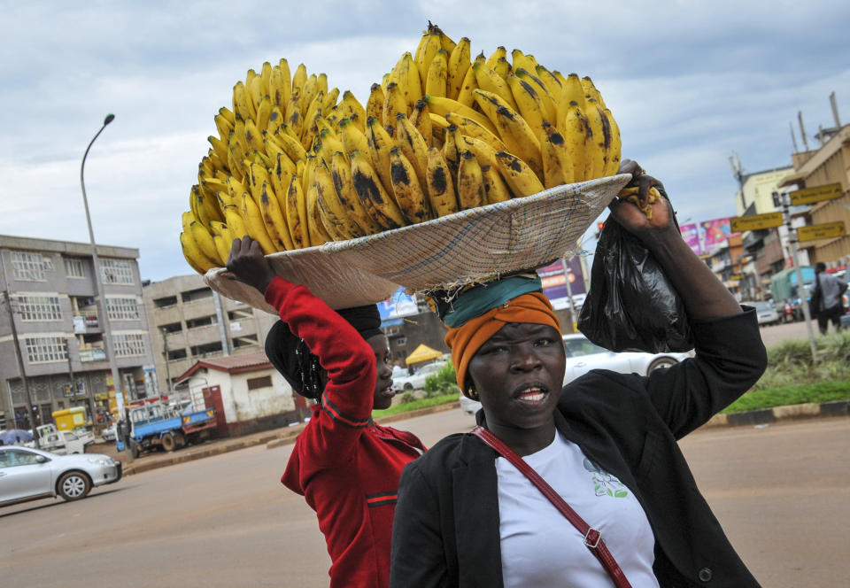 FILE - In this March 26, 2020, file photo, women sell bananas in the street, after traders in markets were prohibited from selling any non-food items in an attempt to halt the spread of the new coronavirus, in Kampala, Uganda. Lockdowns in Africa limiting the movement of people in an attempt to slow the spread of the coronavirus are threatening to choke off supplies of what the continent needs the most: Food. (AP Photo/Ronald Kabuubi, File)