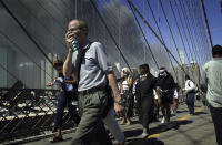 <p>People walk over New York's Brooklyn Bridge from Manhattan to Brooklyn following the collapse of both World Trade Center towers on Sept. 11, 2001. (AP Photo/Mark Lennihan)</p> 