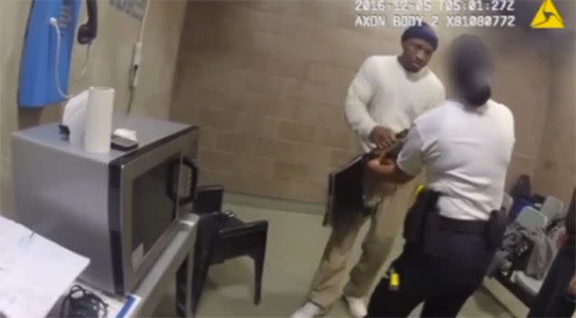 Inmate Jimmie Smith raises his fist to the female corrections officer's face after the guard tried to confiscate a laptop in his possession. Pictures: Cook County Sheriff/Vimeo