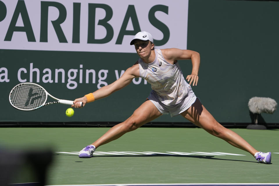 Iga Swiatek, of Poland, returns to Sorana Cirstea, of Romania, at the BNP Paribas Open tennis tournament Thursday, March 16, 2023, in Indian Wells, Calif. (AP Photo/Mark J. Terrill)