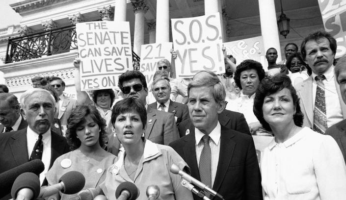 Candy Lightner, founder and president of (MADD) Mothers Against Drunk Driving, is flanked by members of Congress and the administration as she addresses a rally on Capitol Hill, on June 13, 1984, in Washington to seek the support of legislation that would raise the drinking age to 21. Sen. Richard Lugar, R-Ind., and Transportation Secretary Elizabeth Dole, at far right, stand in support with Lightner to support the legislation.