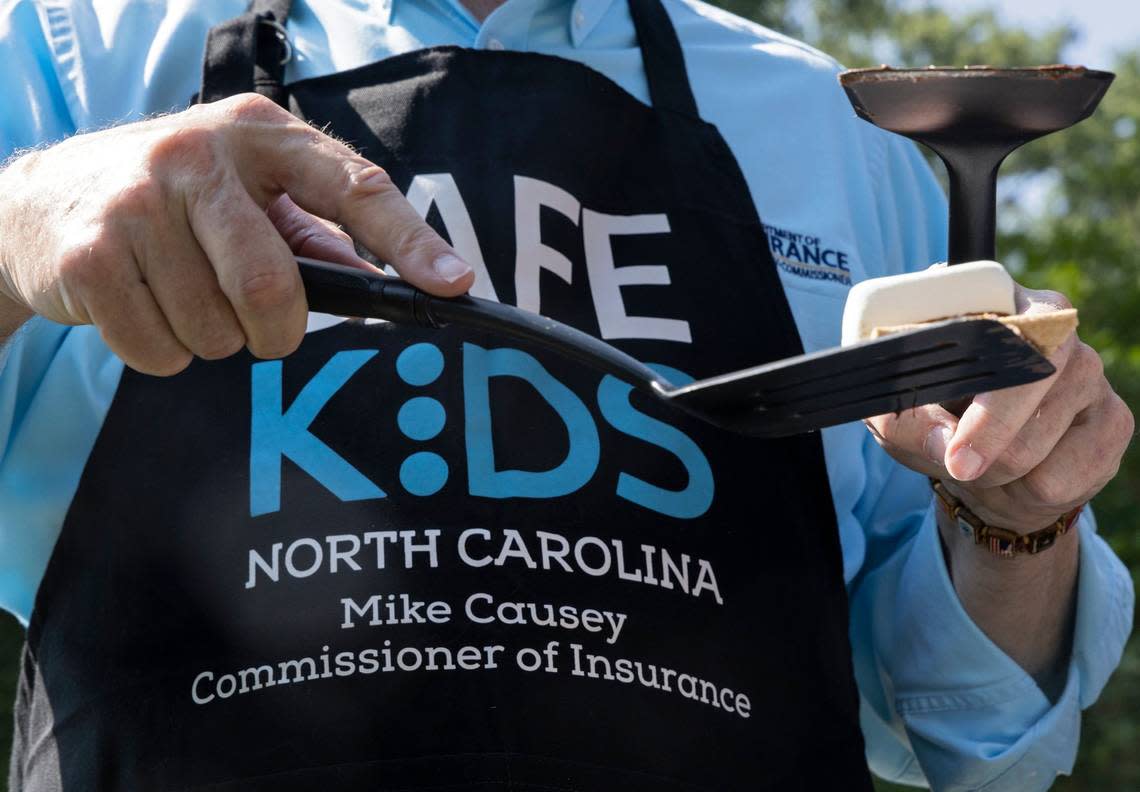 North Carolina Insurance Commissioner Mike Causey serves a s’more during an event held to demonstrate the danger of hot cars in July at Pullen Park in Raleigh, N.C. The s’more components baked inside the vehicle as a thermometer displayed the car’s rising interior temperature.