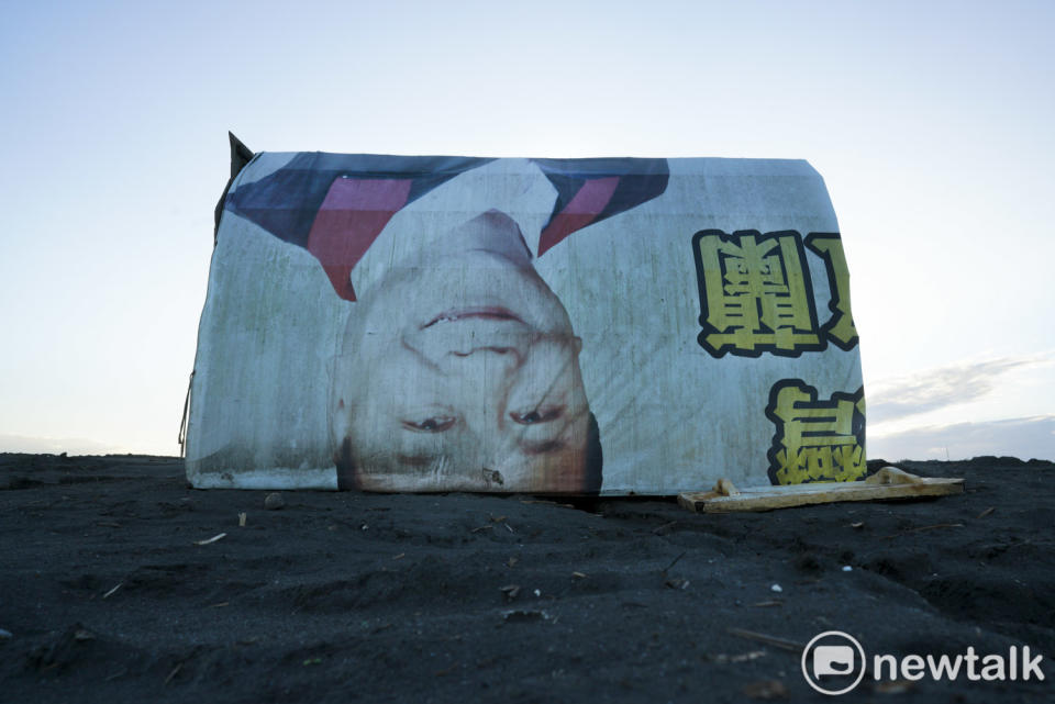 一張競選帆布廣告被扒鰻苗人拿來當作遮風避雨的魚寮。   圖：張良一/攝