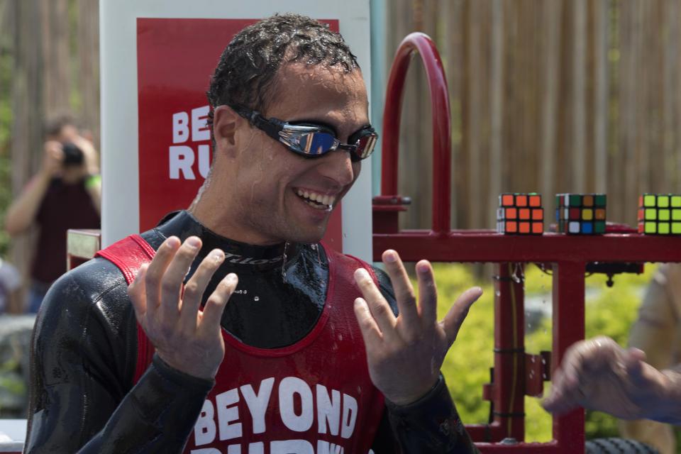 North American Speed Cube Champion Anthony Brooks reacts after breaking the Guinness World Records title for "Most Cubes Solved Underwater In One Breath" at the National Rubik's Cube Championship at Liberty Science Center in Jersey City