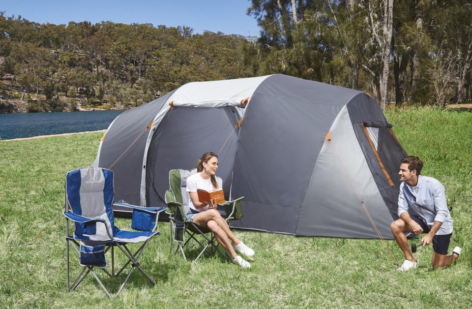 Two people camping by the water with Aldi's 10-Person Tent.