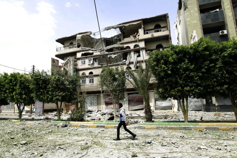 A Yemeni man walks past damaged buildings following an air-strike by the Saudi-led coalition in Sanaa, on September 5, 2015