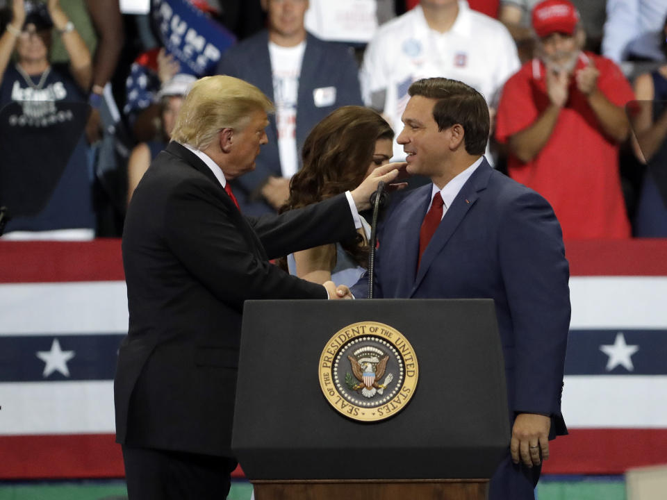 President Donald Trump, left, shakes hands with Florida Gubernatorial candidate Ron DeSantis during a rally Wednesday, Oct. 31, 2018, in Estero, Fla. (AP Photo/Chris O'Meara)