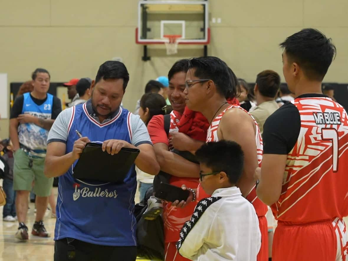 As a league adviser, Ervin Lanada communicates with Grande Prairie Filipino Basketball League teams in English and Tagalog. (Luke Ettinger/CBC - image credit)