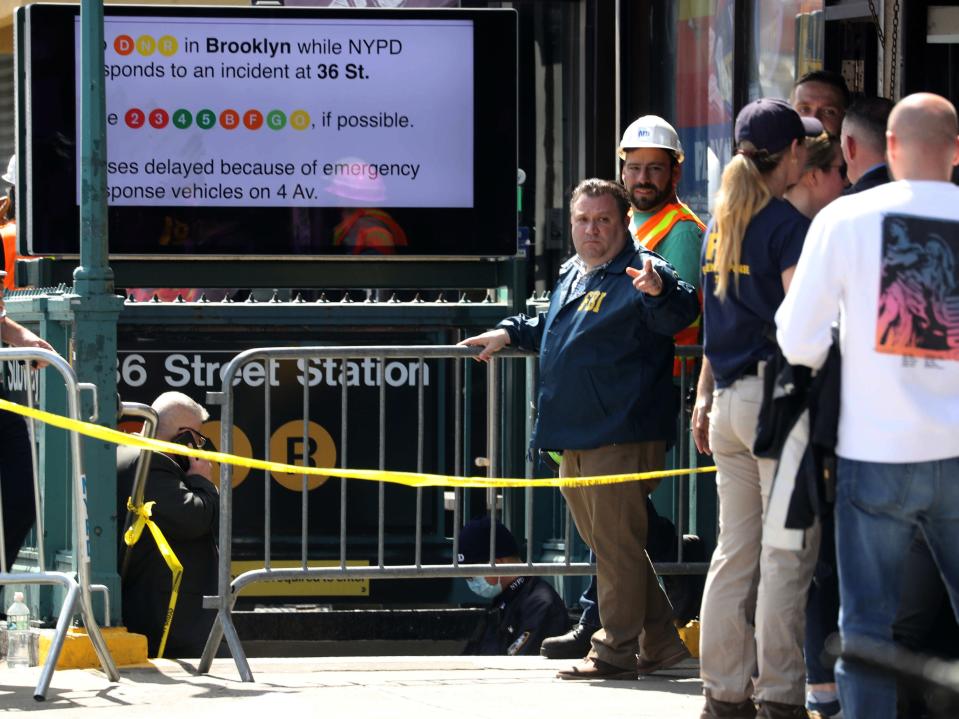 Members of the NYPD work at the scene of a subway shooting in Brooklyn April 12, 2022 where at least 10 people were shot during the morning rush hour.