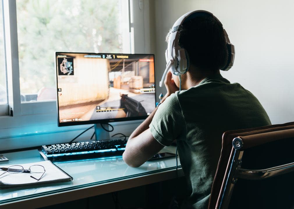 Teenager playing Counter Strike Global Offensive video game on PC.