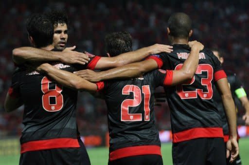 Los futbolistas del Atlético de Madrid celebran el gol de Diego Costa al Hapoel Tel-Aviv en partido del grupo B de la Europa League que el vigente campeón español ganó por 3-0 de visitante el 20 de septiembre de 2012. (AFP | jack guez)