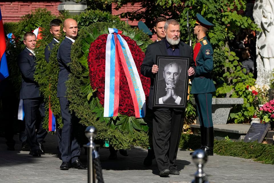 Nobel Peace Prize awarded journalist Dmitry Muratov carries a portrait of former Soviet Union President Mikhail Gorbachev during his funeral at Novodevichy Cemetery in Moscow, Russia, Saturday, Sept. 3, 2022. (AP Photo/Alexander Zemlianichenko).