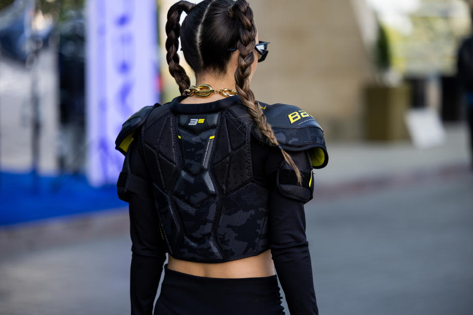 A guest with pigtails wears cropped sports jacket, gloves, Paco Rabanne necklace at VISA Fashion Week Almaty Season VII (Autumn/Winter 2024) on May 04, 2023 in Almaty, Kazakhstan.