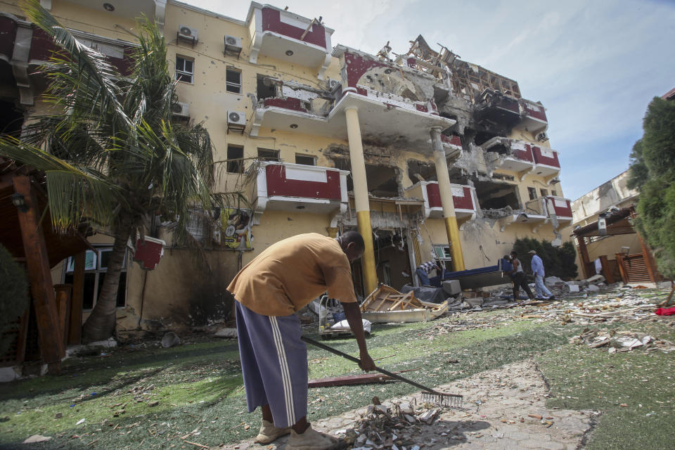 People clear debris outside the destroyed Hayat Hotel, days after a deadly siege by al-Shabab extremists, in Mogadishu, Somalia Wednesday, Aug. 24, 2022. The siege was the longest such attack in the country's history taking more than 30 hours for security forces to subdue the extremists, with more than 20 people killed. (AP Photo/Farah Abdi Warsameh)