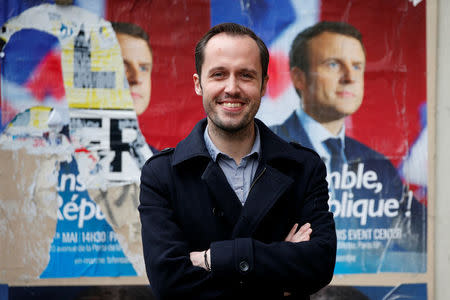 Christophe Brunelle, a teacher and campaigner for Emmanuel Macron, candidate for 2017 presidential election and head of the political movement En Marche !, or Onwards !, poses in front of campaign posters in Paris, France, May 3, 2017. REUTERS/Charles Platiau