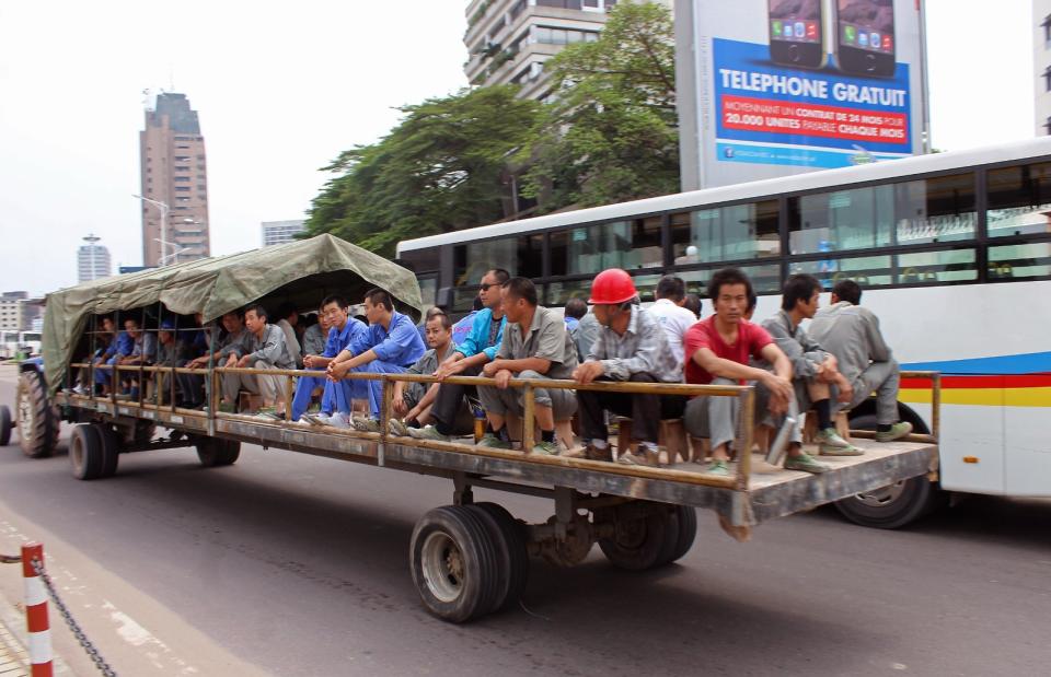 2015年5月20日，剛果民主共和國首都金夏沙，中國工人坐拖車去上班。當時民主剛果政府正在找世界銀行和聯合國官員等外部專家來調查與中國公司簽署的67億美元契約會有何影響。批評者稱，這些契約將會掌控民主剛果的礦產開採權。美聯社