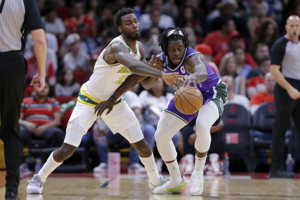 Houston Rockets forward Tari Eason, left, knocks the ball away from Milwaukee Bucks guard Jrue Holiday, right, during the first half of an NBA basketball game Sunday, Dec. 11, 2022, in Houston. (AP Photo/Michael Wyke)