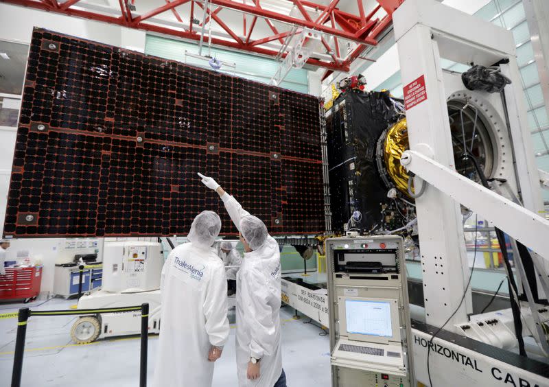 FILE PHOTO: A technician looks at a solar panel on the Inmarsat S-Band/Hellas-Sat 3 satellite in the clean room facilities of the Thales Alenia Space plant in Cannes, France, February 3, 2017. REUTERS/Eric Gaillard