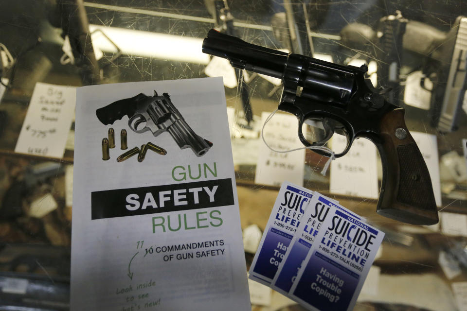 File - In this Feb. 23, 2016 file photo, gun safety and suicide prevention brochures are on display next to guns for sale at a local retail gun store in Montrose Colo. The Democrat-controlled Colorado Legislature sent a "red flag" bill Monday, April 1, 2019, to the governor that calls for taking firearms from people who police say pose a threat to themselves or others. Gov. Jared Polis, also a Democrat, has pledged to sign the measure that would place the state among 13 others that have passed such legislation. (AP Photo/Brennan Linsley, File)